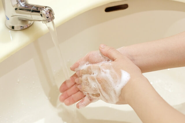 石けんを使って手を洗っている写真